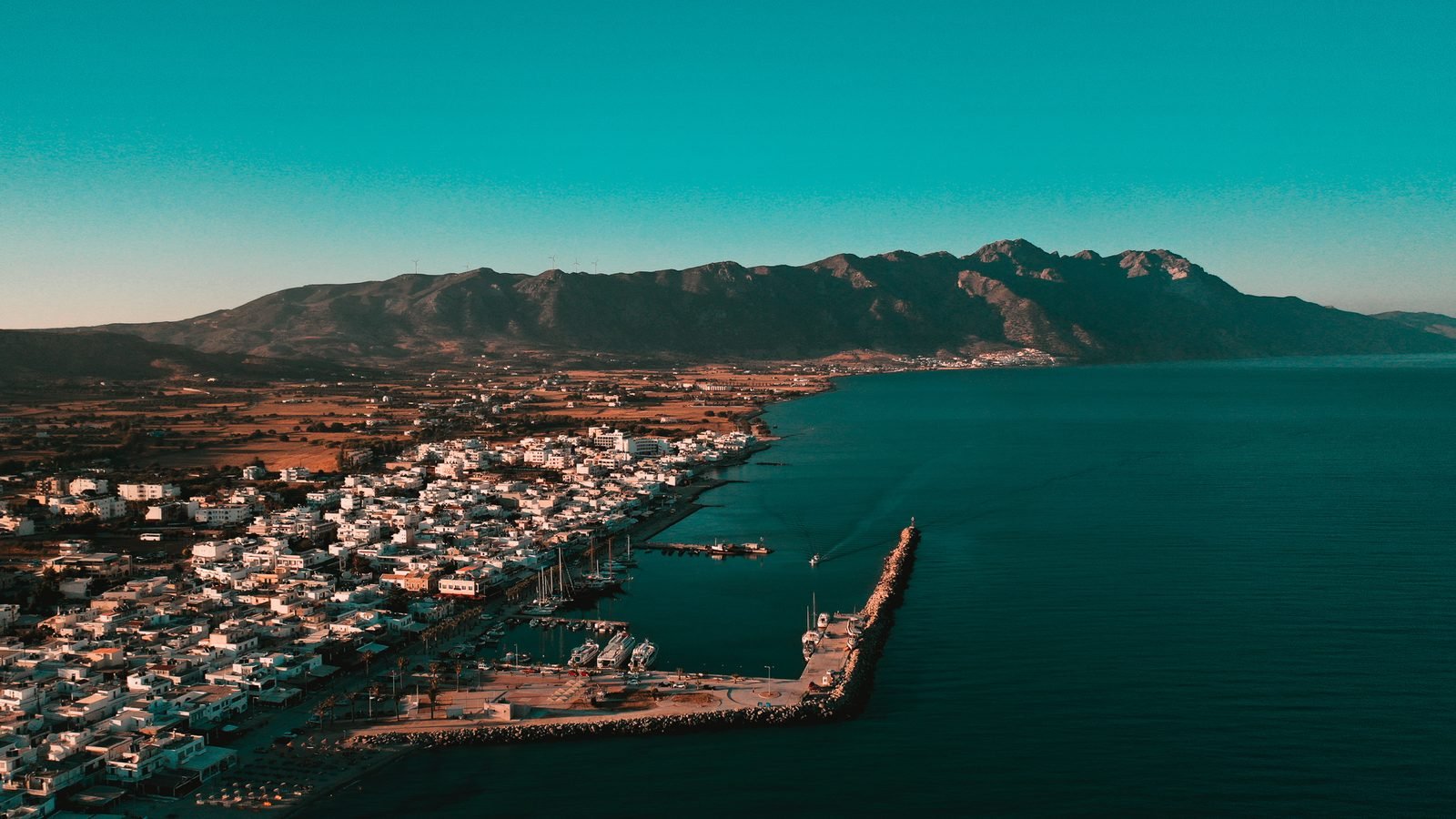 Kardamena vista dall'alto, con la lunga spiaggia di sabbia e il molo del porto
